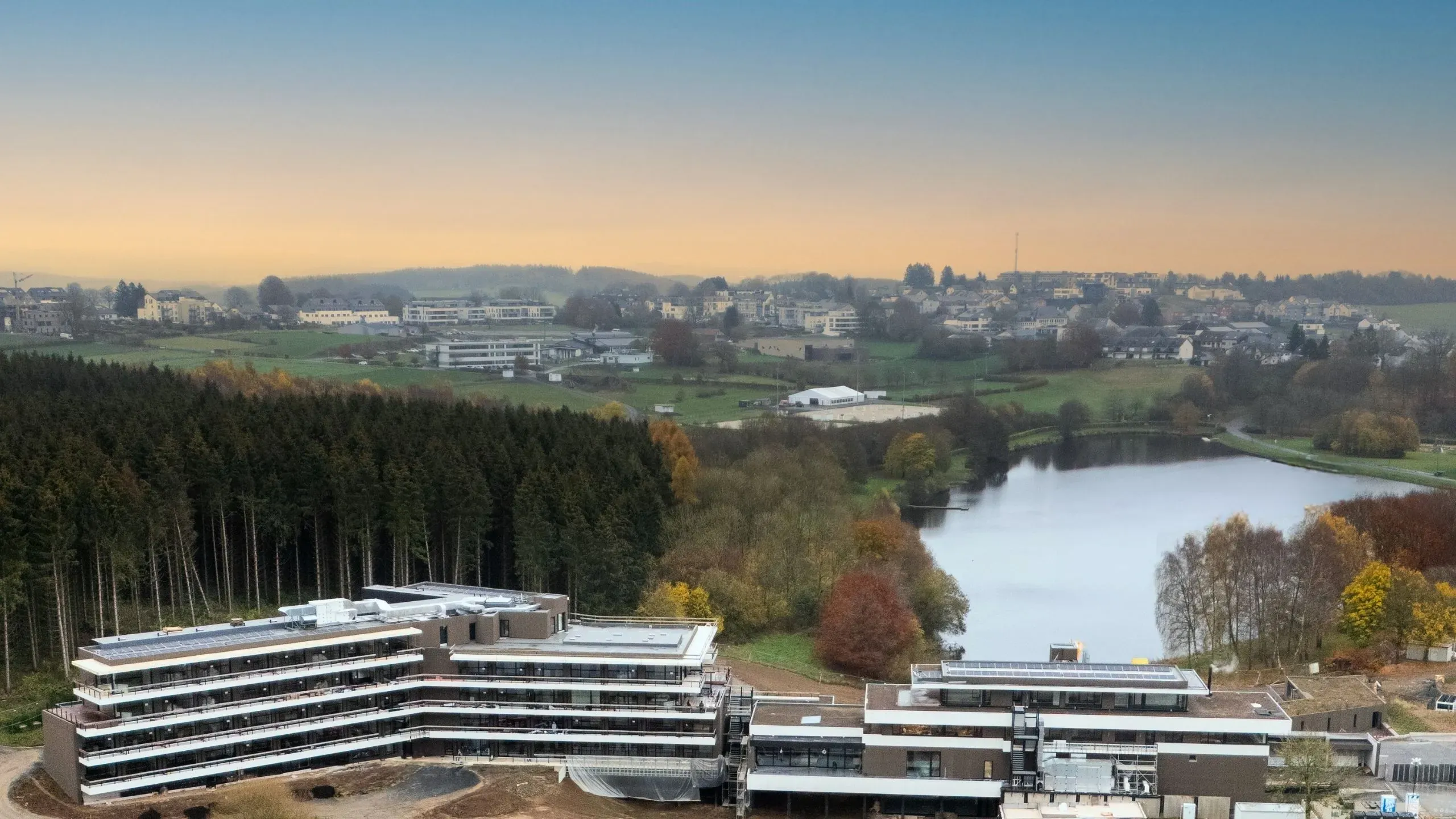Vue aérienne de notre hôtel au Luxembourg, Anatura, avec bâtiments modernes et paysage automnal.