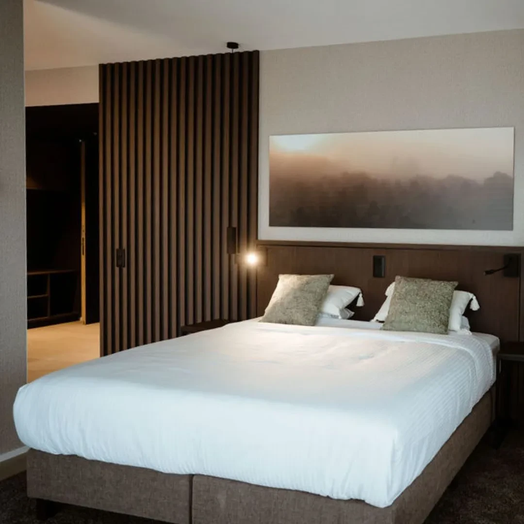 Chambre moderne avec lit double et décoration murale.