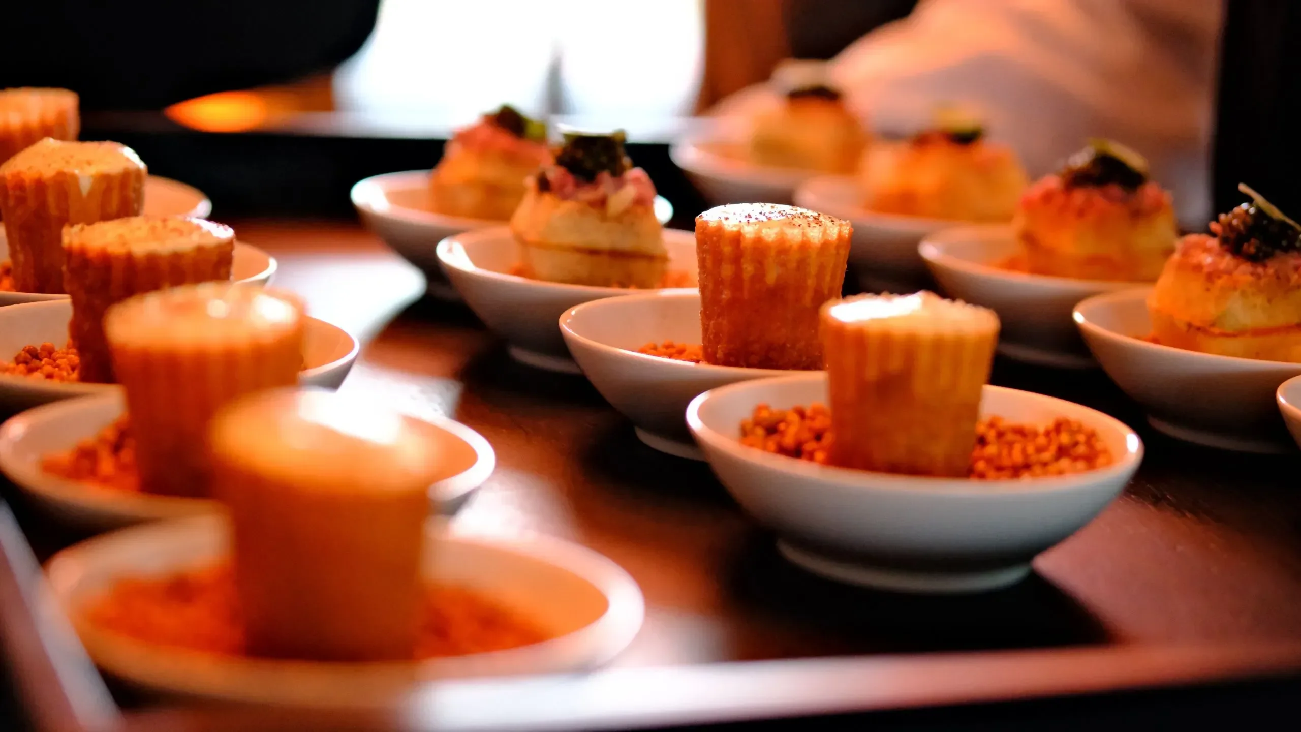 Assortiment de canapés gourmets sur assiettes blanches.