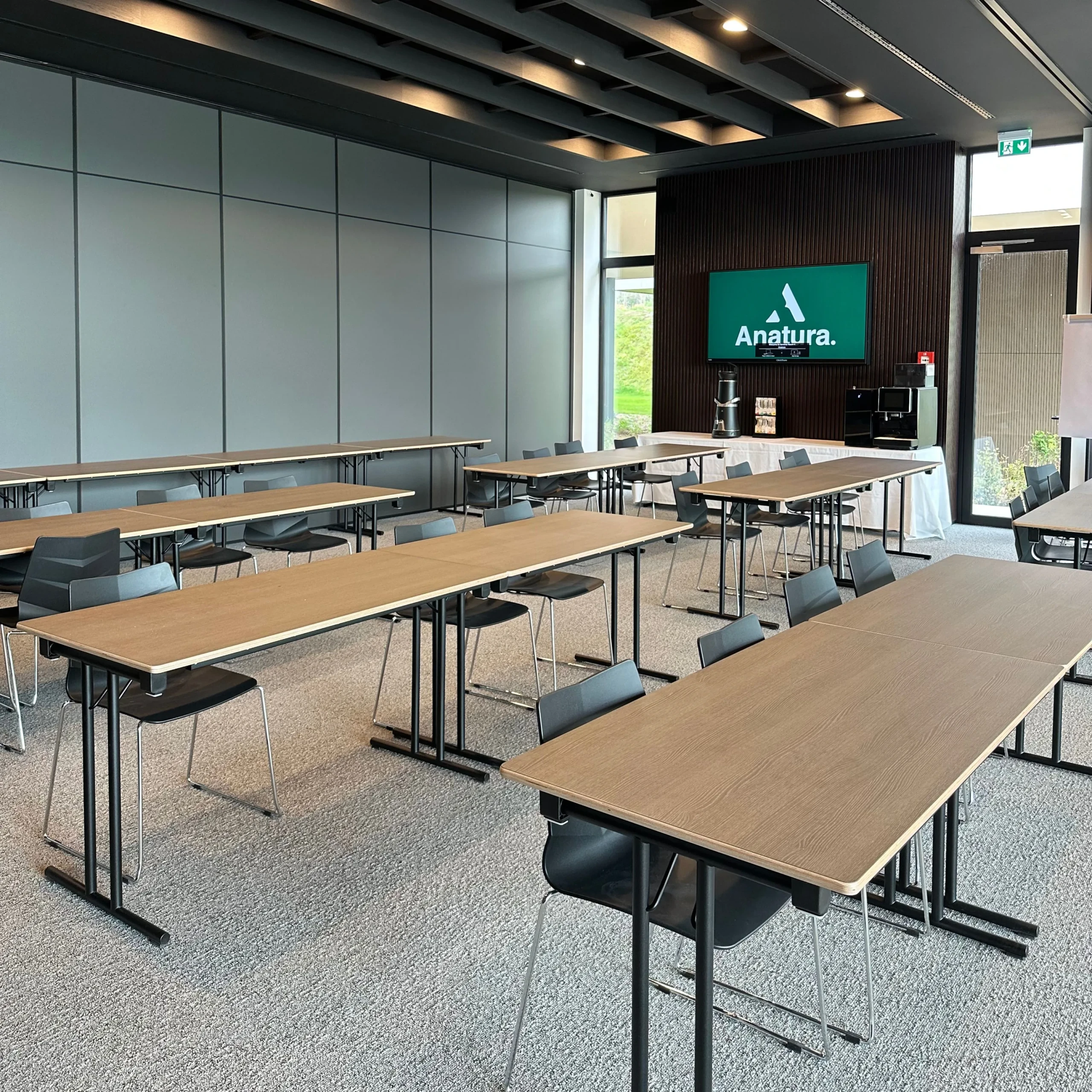 Salle de réunion moderne avec tables et chaises vides.