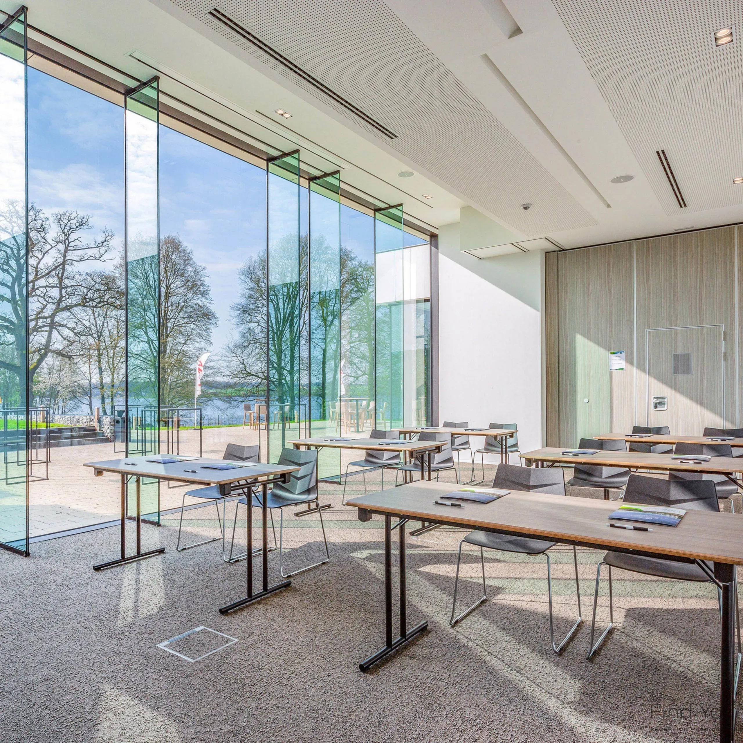 Salle de réunion lumineuse avec grandes fenêtres panoramiques.