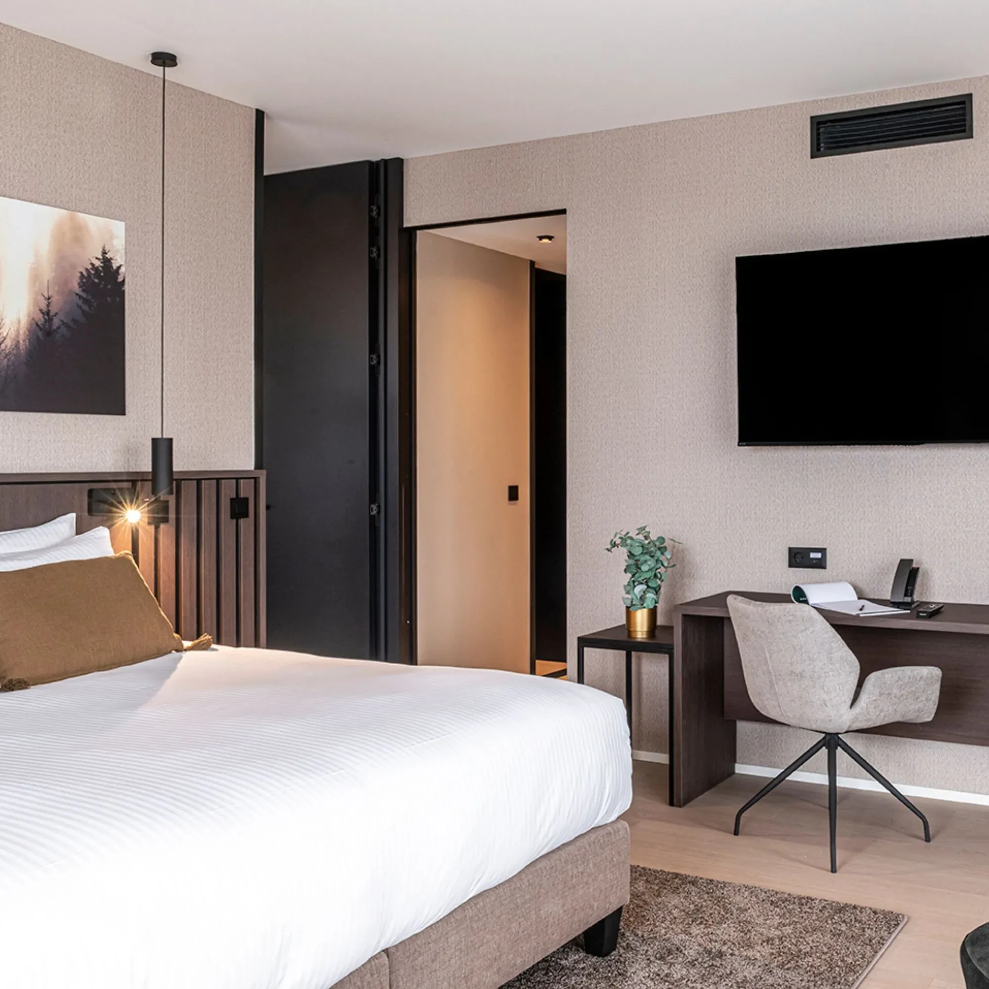 Chambre d'hôtel moderne avec bureau et lit confortable.