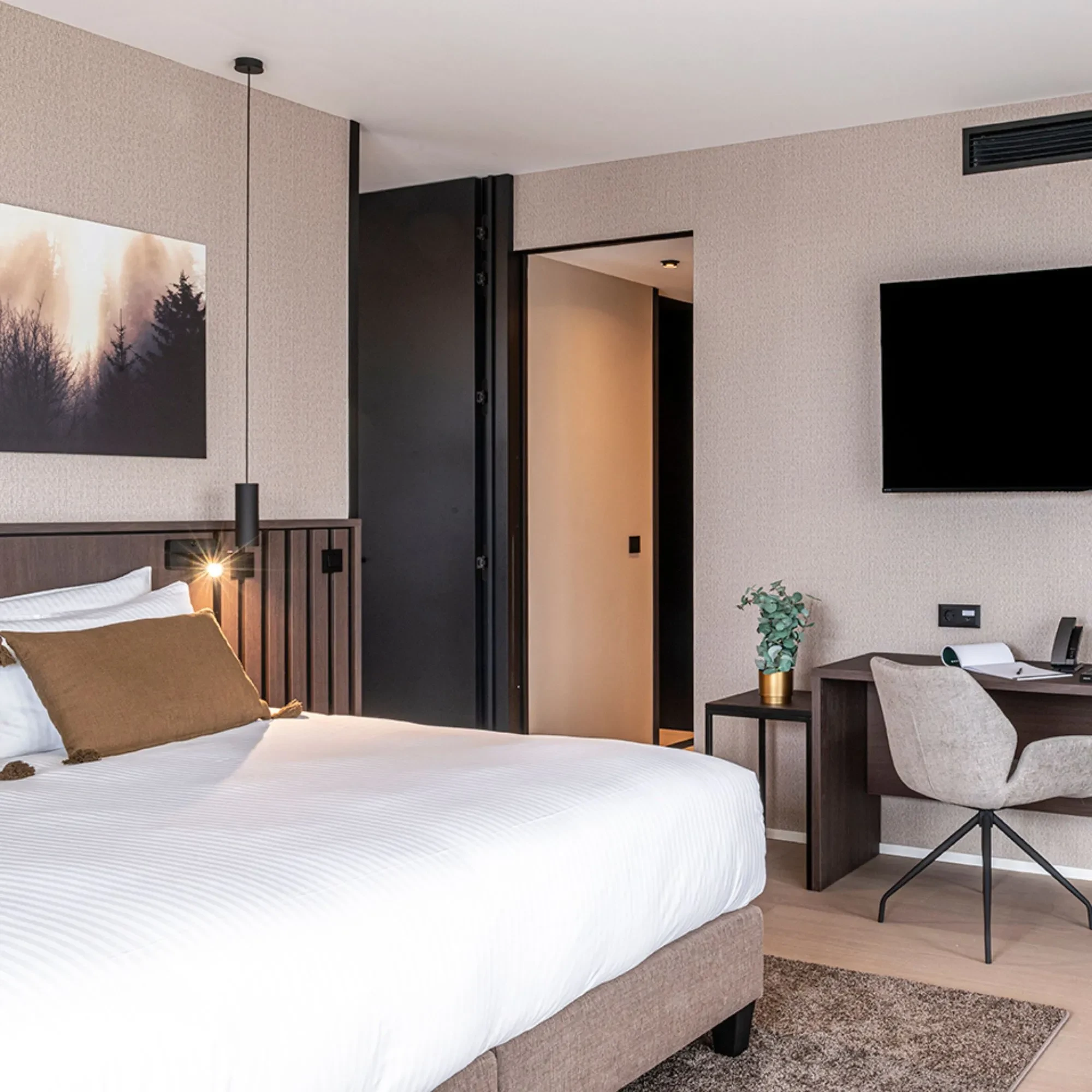 Chambre moderne avec lit, bureau et tableau.